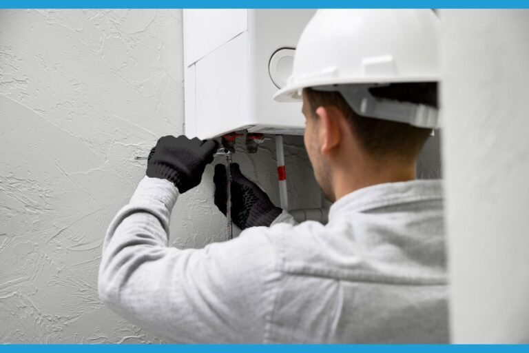 Technicien portant un casque de sécurité effectuant des réparations sur un chauffe-eau mural.